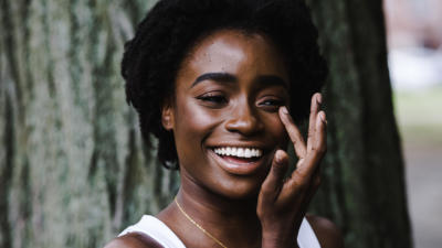 a woman laughing and touching her eye